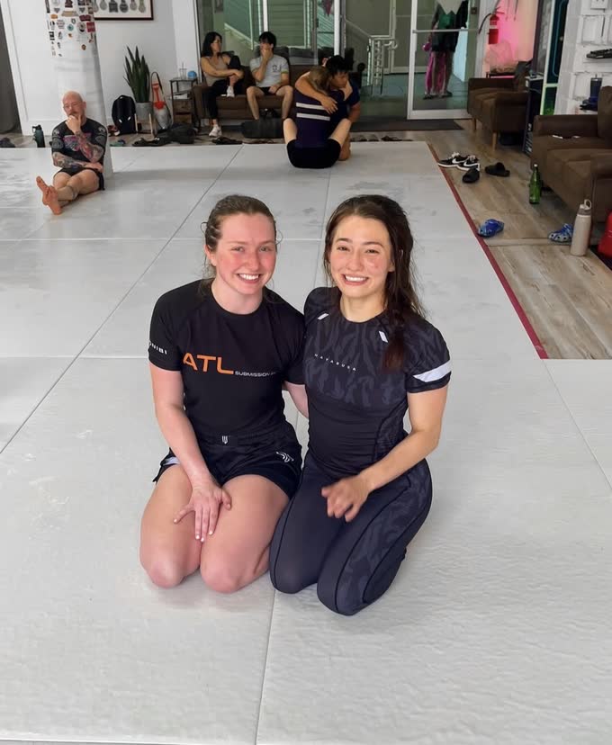 CG Bertrand kneeling on the mats with a training partner